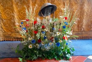 Poppies and cornflowers with a WW1 helment and rosemary to symbolise rememberance