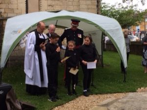 vicar and children under an canopy