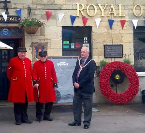 Wreath of poppies, chelsea pensioners in red coats and the Mayor of Cheltenham.